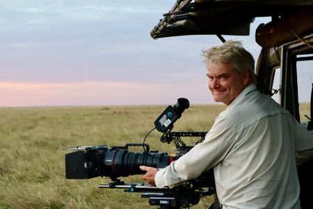 Cinematographer John Aitchison smiles while filming in Maasai Mara, Kenya. (National Geographic/Alice Owen)