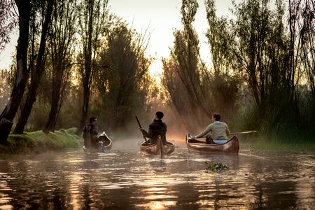 Carlos, Ricardo, and Antoni paddle through the canals of Xochimilco at sunrise. (National Geographic/Jill Worsley)