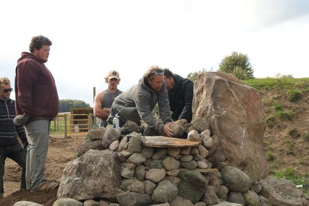 Scott Brady, Andrew Hutton, Seth Doble, Ben Reinhold, and Charles Pol add small rocks to the Pol family farm's pond waterfall. (National Geographic)