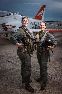 Students LT Carissa Meinster and Captain Steph Harris pose behind a T-45. (Credit: National Geographic/Freddie Claire)