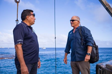 National Geographic Pristine Seas scientist Alan Friedlander (right) is welcomed by Brendon Pasisi after arriving in Niue on the Argo. National Geographic Pristine Seas explored the marine ecosystem in Niue -a small island nation in the tropical Pacific. Local and international scientists surveyed the ocean to understand its health and biodiversity. Thanks to local leadership, traditional knowledge, and strong science, the country has been able to protect large swaths of its marine environment. (National Geographic/Nova West)