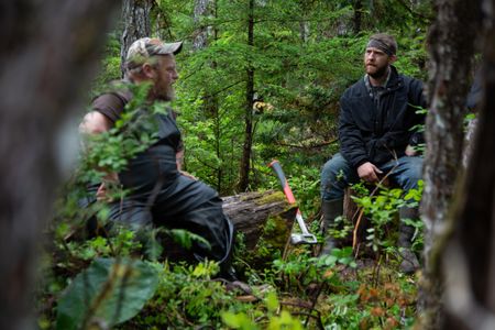 Tim "Curly" Leach gives Oliver Johnson a lesson in logging. (National Geographic/Lukas Taylor)