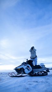 Agnes Hailstone glasses for caribou on top of her snowmobile. (BBC Studios Reality Productions, LLC/Ashton Hurlburt)
