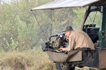 Cinematographer Rolf Steinmann films as rain lashes down around him. (National Geographic/Alice Owen)
