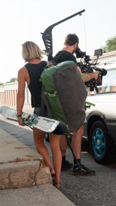 Angel Collinson drops skis off in her storage unit while cinematographer Nick Kraus captures her reflection in the car window.  (National Geographic/Elena Gaby)