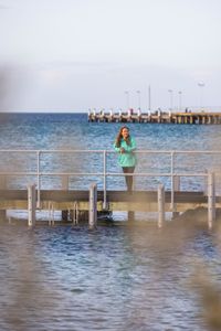 Storyteller and cephalopod expert, Dr Alex Schnell on a pier in Port Phillip Bay.  (photo credit: National Geographic/Harriet Spark)