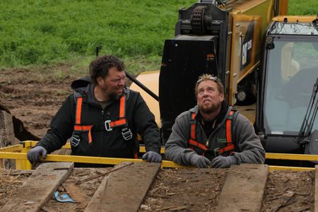 Charles Pol looks over at Ben Reinhold, as he looks at the old barn they are taking down to transport and restore at the Pol family's farm. (National Geographic)