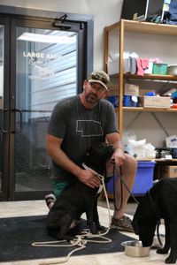Dr. Ben Schroeder tries to comfort one of the black labs that were found while the other drinks some water. (National Geographic)