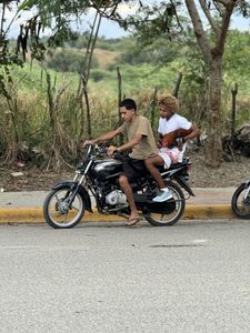 Tico and Manolo ride a bike in Santiago.(Credit: National Geographic)