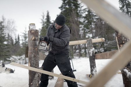 Trapper hangs out while Joel Jacko builds a dock. (National Geographic/Wayne Shockey)