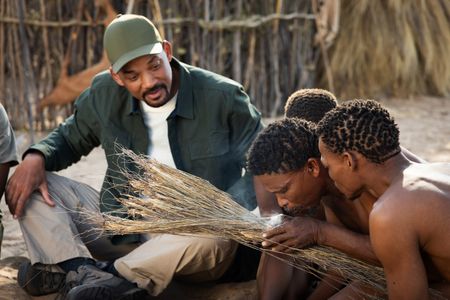Will Smith watches as the San people show him how to start a fire in the Kalahari Desert.  (credit: National Geographic/Kyle Christy)