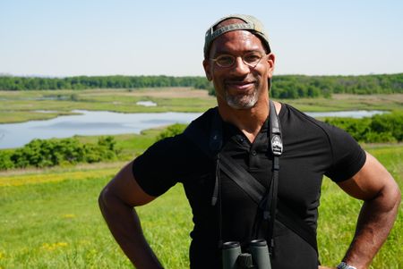 Christian Cooper surveys the new grasslands at Freshkills Park. (National Geographic/Troy Christopher)