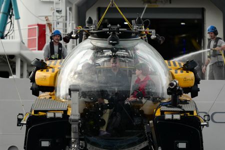 Zoleka Filander, crew Buck Taylor, and Edie Widder sit inside the submarine as it is lifted out of the water. (National Geographic/Mario Tadinac)
