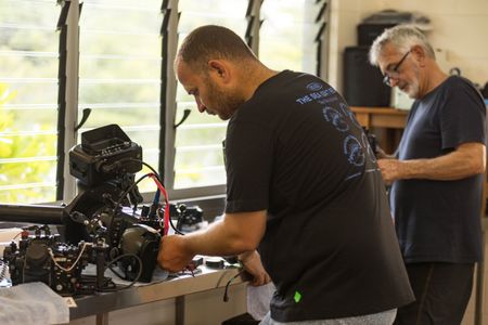 Camera assistant, Woody Spark, and cinematographer, Rory McGuinness, preparing cameras to film the Day octopus sequence on the Great Barrier Reef.   (photo credit: National Geographic/Harriet Spark)