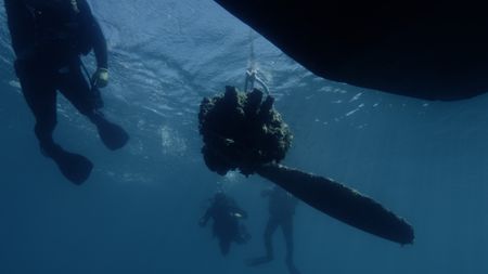 The recovery team lifts the propeller and gear box at the site of the wreck of Lt. Frank Moody' P-39 airplane, lost in the waters of Lake Huron in 1944. (National Geographic)