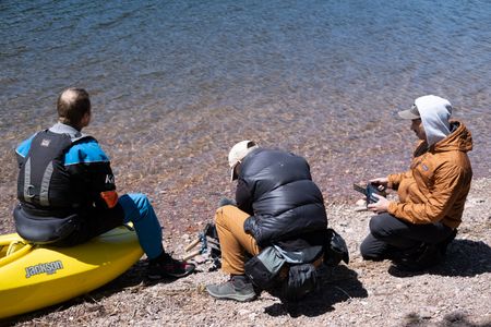 Professional kayaker Ben Stookesberry sits on his kayak and observes the water as DP Ross McDonnell films him from behind, helped by AC Harrison Gayton.  (National Geographic/Harrison Gayton)