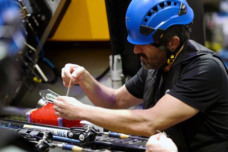 Pedro Afonso works on a camera tag inside of the Sub Hangar. (National Geographic/Mario Tadinac)