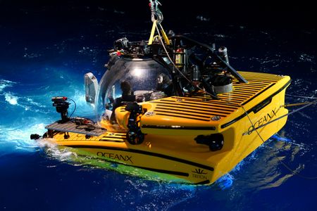 Jorge Fontes and Melissa Marquez sit in the submarine as it's loaded into the water at night.  (National Geographic/Mario Tadinac)