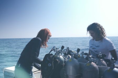 Tanya Houppermans  and Diva Amon checking over diving equipment on Tiger Shark dive boat. (National Geographic/Martin Cass)