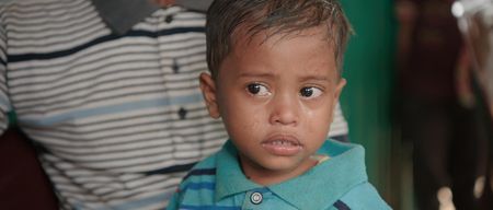 A crying boy who has lost his family sits on Kamal Hussein's lap. Lost and Found, directed by Academy Award winner Orlando von Einsiedel (“The White Helmets”, “Virunga"), is an inspiring story of humanity and heroism in the world’s largest refugee camp, that follows Kamal Hussein, a Rohingya refugee who has dedicated his life to reuniting children with their parents. (Nobel Media)