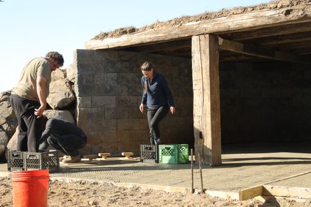 Charles Pol, Ben Reinhold, and Beth Pol use plastic crates and other tools to create grooves in the wet concrete to provide better drainage of the sheep's excrements. (National Geographic)
