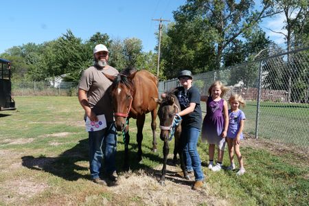 Joey Stansberry and his kids Harper, Hadley, and Haivyn are at the clinic with their four-month-old foal, Baylor, who has a lump on his flank. (National Geographic)