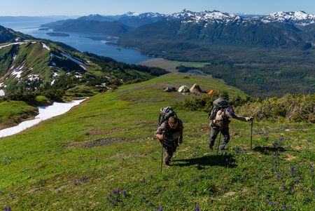Bear Guide Bjorn Dihle and Camera Operator Rick Smith hike up a mountain from their camp to reach their filming location. (National Geographic for Disney/Colin Arisman)