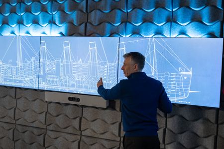 Simon Benson examines blueprints of the RMS Titanic. (National Geographic/Gary Moyes)