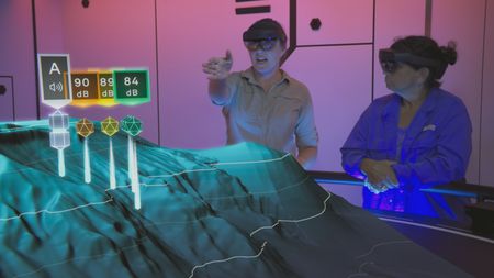 Kerri Seger points out acoustic data points to Mithriel Mackay in the Hololab as they analyze the results of Mithriel's acoustic experiment.  (National Geographic)