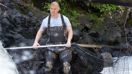 Troy Brockway fishes for salmon with a dip net. (National Geographic/Mickey Ramos)