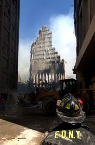 9/11: ONE DAY IN AMERICA - A New York City fire fighter looks up at what remains of the World Trade Center after its collapse following a Sept. 11 terrorist attack. (U.S. Navy Photo by Photographer's Mate 2nd Class Jim Watson)
