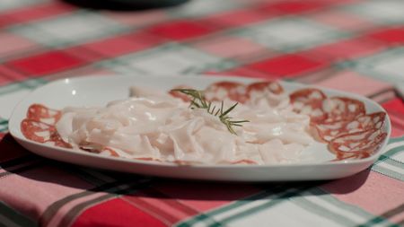 A beautifully plated selection of Colonnata's famous lard and salami, ready to be enjoyed by host Stanley Tucci.  (credit: National Geographic)