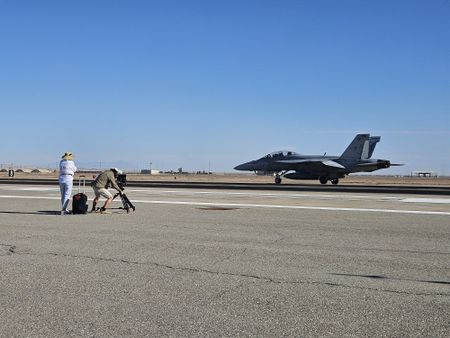 DOP Jon Southgate-Sayers sets his tripod up to film F-18s taking off. (Credit: National Geographic/Lyndsi Gutierrez)