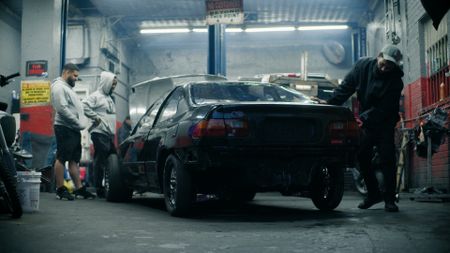 Riders and mechanics work on their cars before the Bronx street race. (National Geographic)