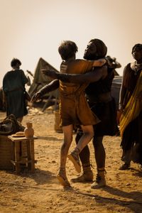 Avianius, played by Frankie Treadaway, leaps into the embrace of Marcus Masurius, played by Theo Ogundipe, overjoyed at finding each other in the Pompeii displacement camp. (National Geographic/Darrin Zammit Lupi)