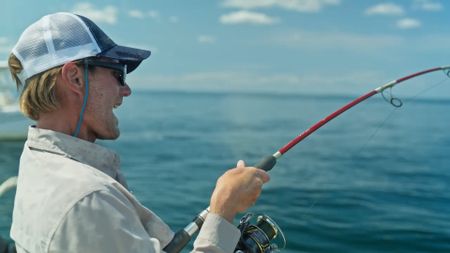 Capt. Greg Metzger has a baby great white shark on the line and is wrestling to try and bring it on board so the team can tag it. (National Geographic/James Blake)