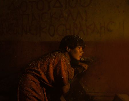 Avianius, played by Frankie Treadaway, clings to the wall of a building in the streets of Herculaneum, unable to find his way in the dark streets as ash falls around him. (National Geographic/Darrin Zammit Lupi)