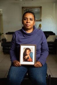 Michelle Harrison, sister of Melody Harrison, holds a picture of her sister. (National Geographic/Tom Beard)