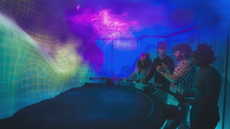 Melissa Marquez, Eric Stackpole, Andreas Alexander and Zoleka Filander are in the OceanXplorer's Hololab to review the results from the glacial drifter data. Their results highlight how meltwater exasperates the melting of the glacier. (National Geographic)