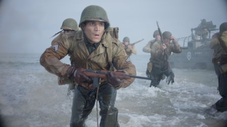 Corporal William Dabney (played by Joshua Riley) arrives on Omaha beach in a scene of a WW2 historic reenactment production for "Erased: WW2's Heroes of Color." Corporal Dabney served with the 320th Barrage Balloon Battalion on D-Day. (National Geographic)