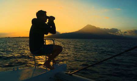 Host, Bertie Gregory, scanning the water at sunrise.  (credit: National Geographic/Adam Boyle)