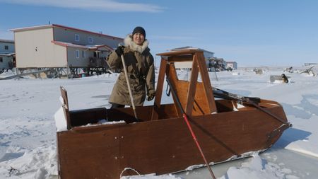 John 'Sonna Boy' Pingayak III packs the family sled before they all head out towards the ice. (National Geographic)