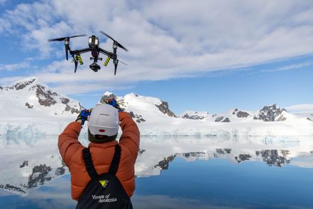 Crew launch a filming drone by hand to avoid collision with the rigging on the yacht. (National Geographic for Disney/Holly Harrison)