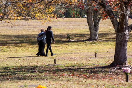 Marilyn Brown walks with her son, Braylon Brown, in the memorial gardens where her brother David has rested in an unmarked grave for 28 years. (National Geographic/Tom Beard)