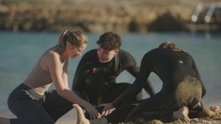 Drama recreation shoot of the aftermath of Caleb Swanepoel's shark attack and being helped on the beach. (National Geographic/Samuel Gonzalez)