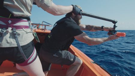 Kerri Seger and Aldo Kane ready a camera tag as the team get ready to tag the mother humpback and her calf. (National Geographic)