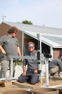 Andrew Hutton and Ben Reinhold work on the Robot Garden system in the Pol family farm's garden. (National Geographic)