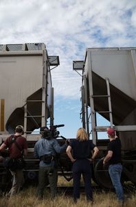 The crew and Mariana van Zeller stand around trains in Culiacán, Mexico. (National Geographic)