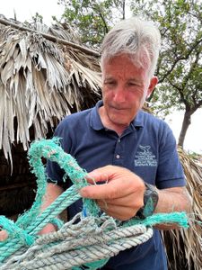 Whale Rescue Expert Ed Lyman examines fishing line cut loose from an entangled humpback whale. (National Geographic for Disney/Rory Dormer)