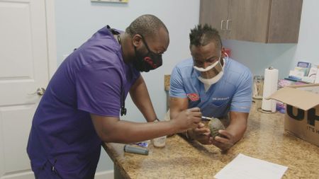 Dr. Hodges and surgery tech Paul give some medicine to Raphael, the Red-Eared Slider. (National Geographic for Disney)